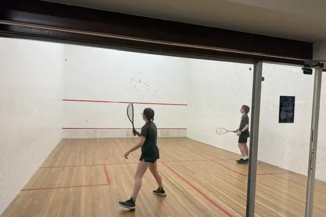 <p>SQUASH COMPETITION: Eric serving to Holly. </p>\\n