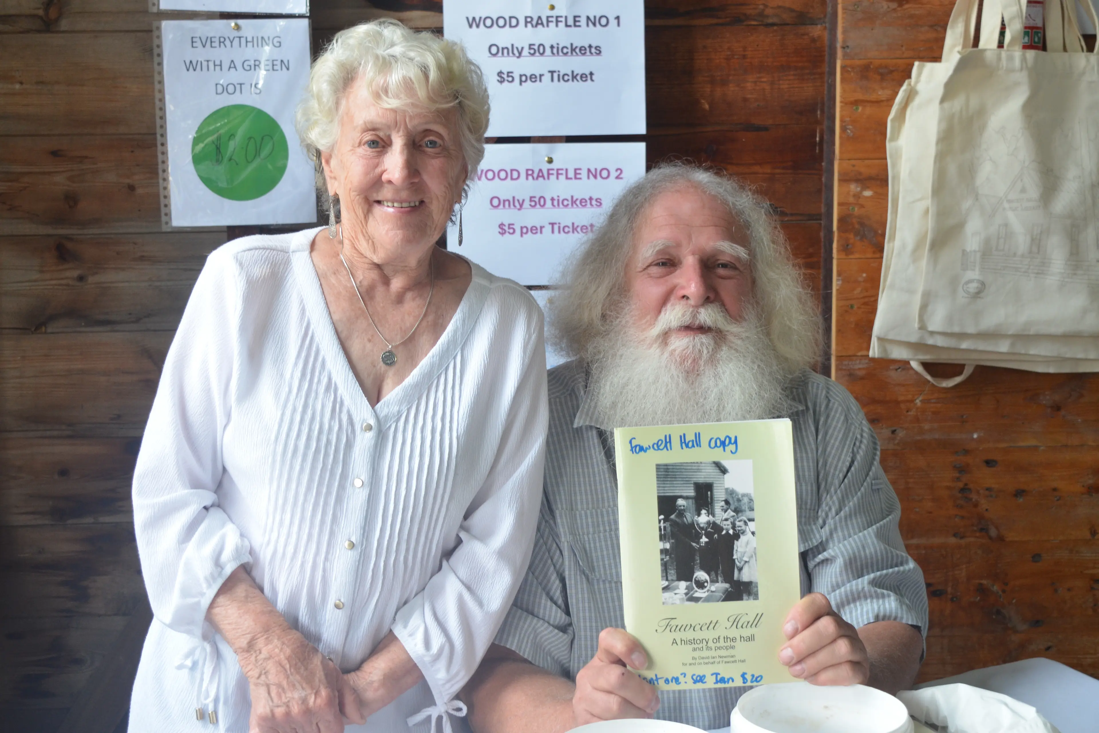 <p>LOCAL SPIRIT: Joy Burchell and Ian Newman on the door and selling raffle tickets, alongside showing off the history of the hall book. PHOTO: Bailey Dixon</p>\\n